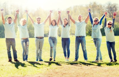 Team of people outside on a field cheering together