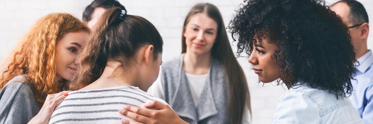 Image of support group of people comforting a person
