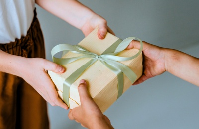 hands passing a wrapped gift to another person