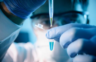 Research image of scientist adding liquids together in a test tube