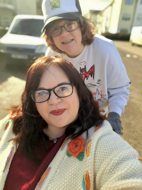 Photo of sally and Ace outside, smiling for the camera