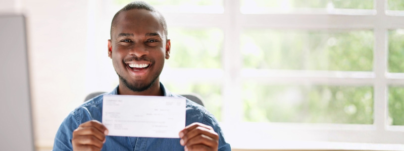 Photo of happy man holding up a cheque