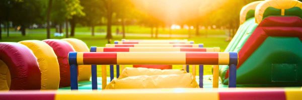 image shows inflatable obstacle course in a sunny field