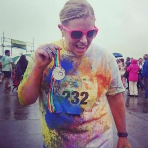 Photo of Hailee smiling after a race and holding up a medal