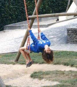 Photo of Rebecca as a child, playing on a swing