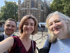 Photo of three people smiling for a selfie in central London.